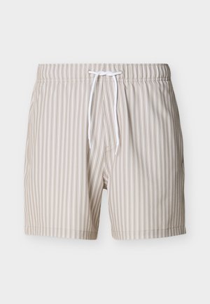 Beige og hvite badeshorts med vertikale striper, elastisk midjebånd og hvit snor, vist på en ensfarget bakgrunn.
