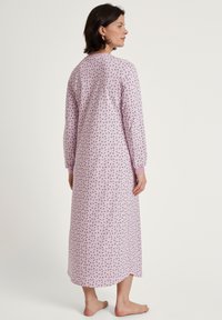 Gonna da notte a maniche lunghe in tessuto rosa chiaro con un motivo floreale, con scollatura a girocollo e polsini rosa, che si estende fino a metà polpaccio.