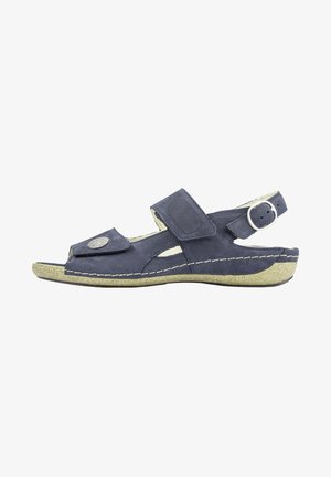 Navy blue suede sandal with an open toe, adjustable strap, decorative metal accent, and a textured light-colored sole.