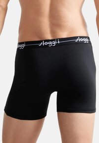 Boxer briefs neri con una morbida vita e il logo "sloggi" bianco, realizzati in un tessuto liscio e elasticizzato che si adatta al corpo.
