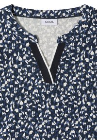 Top con motivo a quadretti blu e bianco con scollo a V evidenziato da un bordo nero e bianco e un'etichetta del marchio "CECIL" sul colletto.