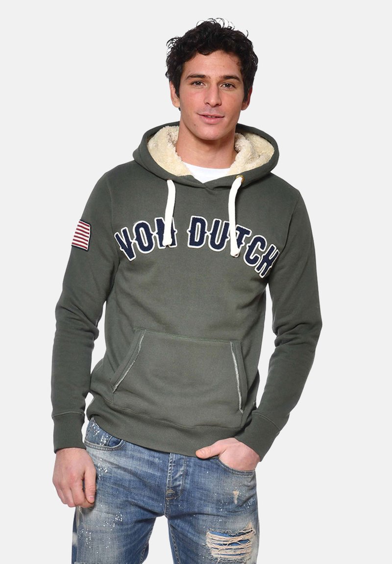 Hoodie vert olive avec doublure en fourrure blanche et cordons de serrage, arborant un grand imprimé "VOLD DUTCH" et un patch du drapeau américain sur la manche.