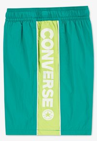 Τιρκουάζ μαγιό σορτς με κάθετη πράσινη λωρίδα λάιμ που φέρει τη λέξη «CONVERSE» με έντονα λευκά γράμματα και κυκλικό λογότυπο στο τελείωμα. Ελαστική ζώνη μέσης.