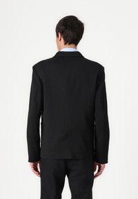 Schwarz strukturierter Blazer mit einem subtilen Texturmuster, ausgestattet mit langen Ärmeln, Reverskragen und geradem Saum.