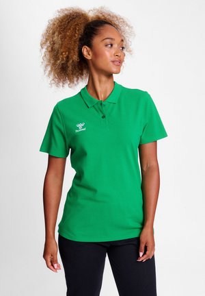 Polo vert avec col, manches courtes et trois boutons. Présente un logo blanc sur le côté gauche. Texture de tissu lisse.