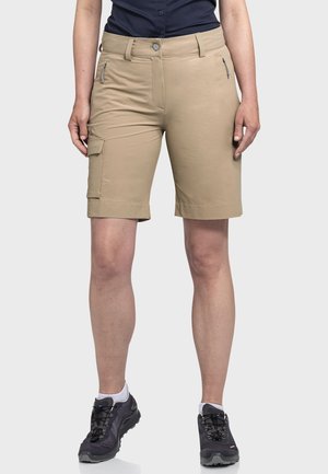 Beige Cargo-Shorts mit schmaler Passform. Mit Seitentaschen, Reißverschlussdetails und umgeschlagenem Saum. Tragen mit dunklen Wanderschuhen.