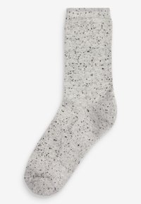 Chaussettes gris clair avec un motif de tricot texturé. Taches noires dispersées. Poignet côtelé. Longueur standard avec orteil et talon renforcés.