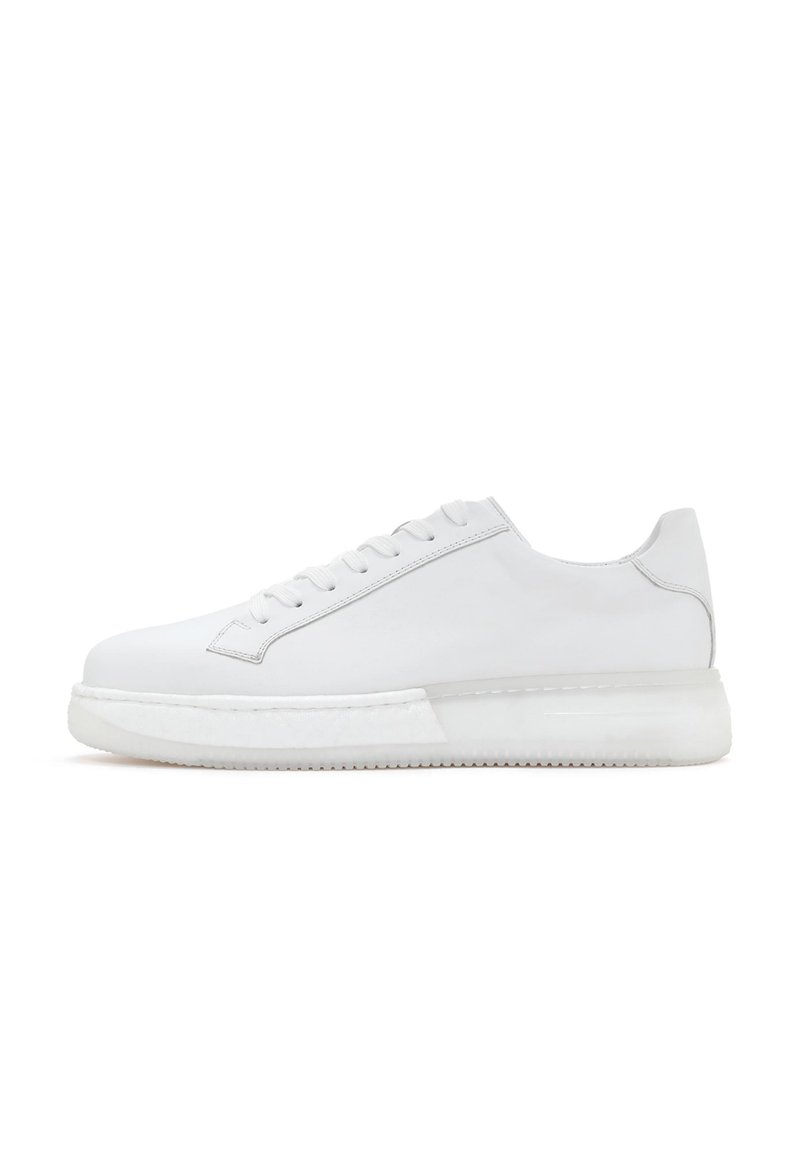 Sneaker en cuir blanc avec une texture lisse, un bout rond et six œillets. Équipé d'une semelle en caoutchouc translucide épaisse et d'un design minimaliste.