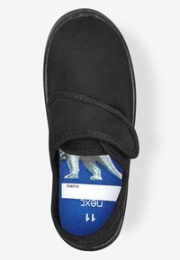 Schwarzer Slipper mit einem strukturierten Obermaterial aus Canvas. Verfügt über einen Klettverschluss und eine blaue Innensohle mit einem Dinosauriermotiv und Bereich für ein Namensschild.