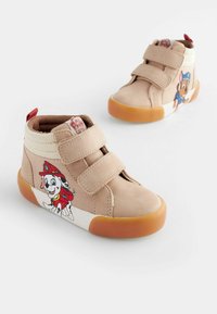 Beige High-Top-Sneaker mit zwei Klettverschlüssen, versehen mit grafischen Designs von Figuren an den Seiten, Gummisohlen und strukturierten Akzenten.