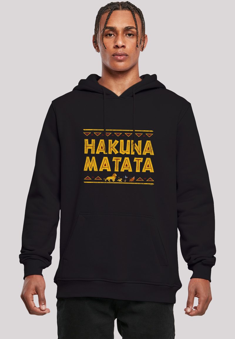 Fekete kapucnis sweatshirt, amelyen sárga színű "HAKUNA MATATA" felirat található, geometrikus mintákkal és állati sziluettekkel díszítve. Puha anyag, elülső zseb.