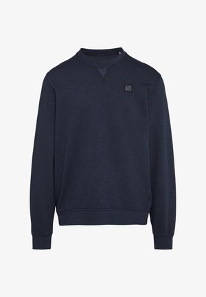 Mornarsko modra trenirka iz mešanice bombaža. Ima okroglo ovratnik, rebraste manšete in majhno nalepko z logotipom spredaj.