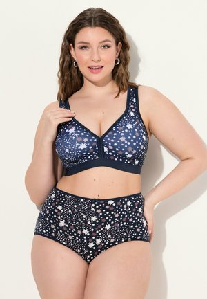 Laivansininen bralette, jossa on tähtikuvio, pehmeää kangasta, säädettävät olkaimet ja yhteensopiva korkeavyötäröinen alushousu samankaltaisella muotoilulla.