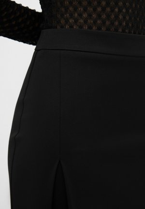 Zwarte rok van een gladde stof met een elegante uitstraling, zijsplit en strakke lijnen, benadrukt door een aansluitende tailleband.