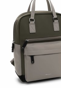 Sac à dos synthétique vert et gris avec deux poignées sur le dessus, poche zippée à l'avant et base noire. Texture lisse et détails de couture contrastés.