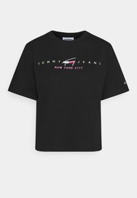 Black cotton T-shirt with a relaxed fit. Features rainbow-colored "TOMMY JEANS NEW YORK CITY" text in a bold font across the chest.