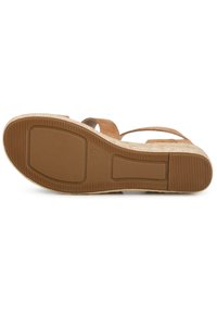 Sandalo con zeppa in suede marrone, dotato di una suola in gomma texturizzata, caratterizzato da un tacco piatto, punta aperta e due cinturini regolabili.