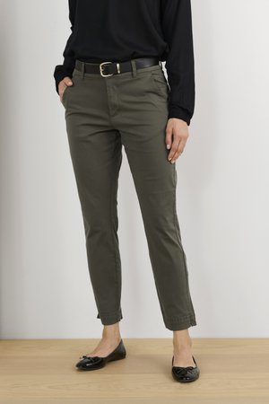 Kaki-Chinos im Slim Fit mit seitlichen Taschen, einem schwarzen Gürtel mit goldener Schnalle und dezenten Aufschlägen am Saum.