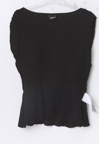 Top nero realizzato in tessuto testurizzato con un motivo ondulato, caratterizzato da un ampio scollo e un orlo svasato. Include un'etichetta per le cure sul lato.