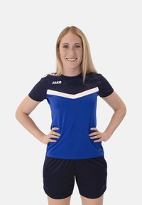 Maglietta sportiva blu con maniche corte blu scuro e dettagli bianchi, caratterizzata da un motivo testurizzato e un logo sulla parte superiore sinistra del petto. Pantaloni corti neri sotto.