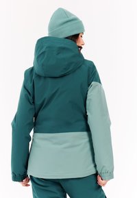 Jade- und minzgrün farbblockierte Jacke mit Kapuze, elastischen Bündchen und lockerer Passform. Glatte Textur, entworfen für den Einsatz im Freien.