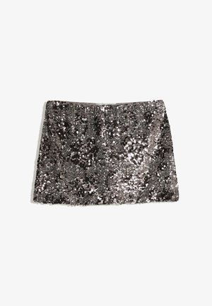 Jupe en sequins, design court et droit, fabriquée en tissu avec des sequins noirs et argentés, créant une surface texturée et scintillante.