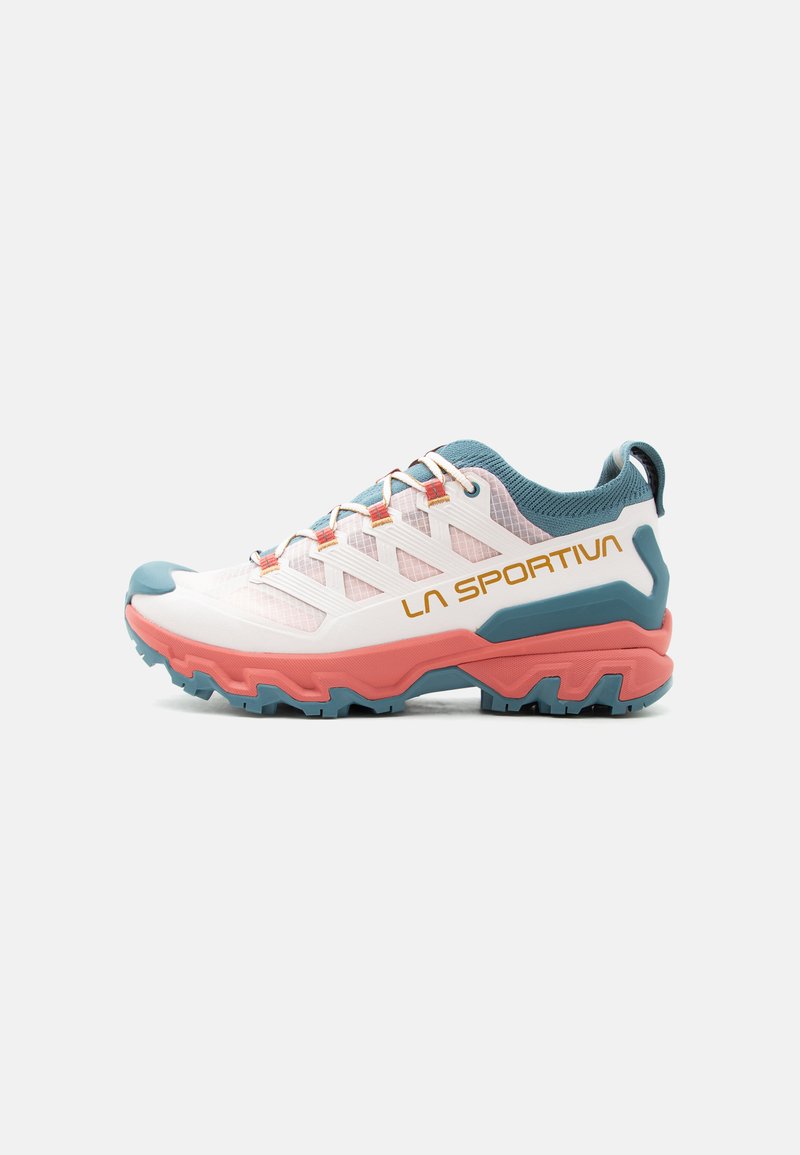 Chaussure de trail running blanche et corail avec des accents turquoise, une semelle agressive et le logo "La Sportiva" sur le côté, vue de profil.