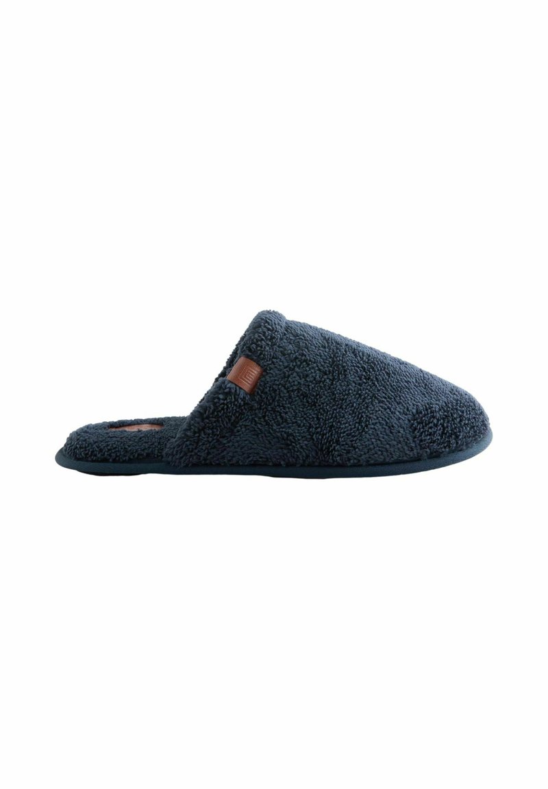 Dunkelblaue Fleece-Hausschuh mit offener Ferse und braunem Lederetikett an der Seite, entworfen für den Komfort im Innenbereich.