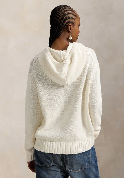 Φούτερ σε κρεμ απόχρωση με υφή πλεκτού, ριμπ τελείωμα και απαλό, άνετο κόψιμο. Διαθέτει κουκούλα και ανοιχτό πλεκτό σχέδιο.