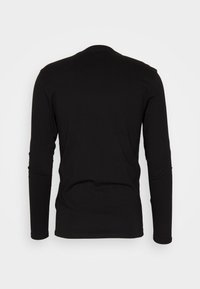 Zwarte langemouwen shirt van gladde stof, met een ronde hals en een eenvoudig ontwerp zonder patronen of accenten.