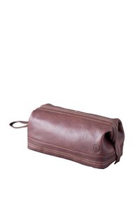 Brown leather cosmetic bag with a cylindrical shape, zipper closure, and a stitched accent at the base. Includes a loop for hanging.