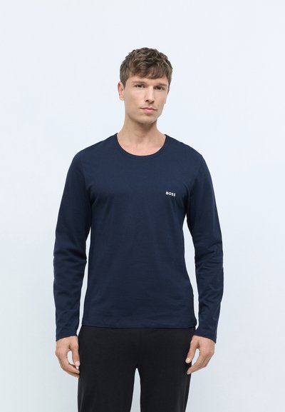 T-shirt à manches longues bleu marine en coton doux, avec un col rond et un petit logo "BOSS" blanc sur la poitrine gauche.