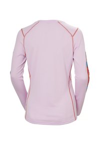 Camisa de manga larga en tela rosa claro con superficie texturizada, con costuras de hilo rojo a lo largo de las costuras y acentos de patrón colorido en las mangas.