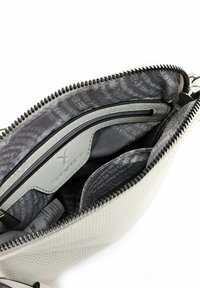 Hvid tekstureret lædertaske med grålæder indeni; har lynlåslomme, rum og trykt design. Lynlåslukning øverst.