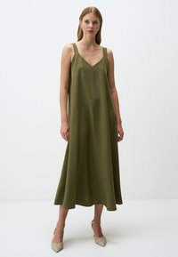 Abito midi senza maniche di colore verde oliva con scollatura a V. Tessuto morbido, spalline larghe e silhouette a campana. Leggera drappeggiatura all'orlo.