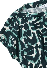 Top de manga corta con estampado de leopardo en verde oscuro, azul claro y blanco roto. Confeccionado en una tela suave, tiene un escote redondo y un corte holgado.
