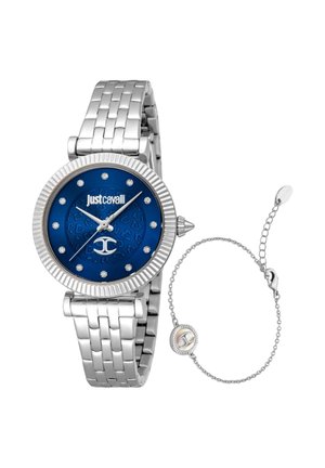 Zilverkleurige metalen armbanduurs met blauwe wijzerplaat, kristallen uurmarkeringen, Just Cavalli-logo en een delicate zilveren kettingarmband ernaast.