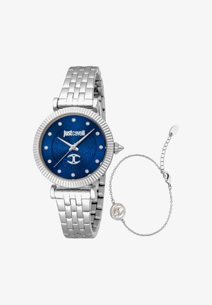 Zilverkleurige metalen armbanduurs met blauwe wijzerplaat, kristallen uurmarkeringen, Just Cavalli-logo en een delicate zilveren kettingarmband ernaast.