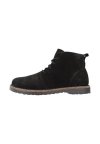 Stivaletti neri in suede, con punta arrotondata, design con lacci e suola in sughero testurizzato. Presentano un piccolo tacco e una linguetta per facilitare l'indosso.