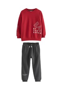 Red long-sleeve sweatshirt with white text and dark gray drawstring jogger pants featuring side pockets and cuffed ankles.