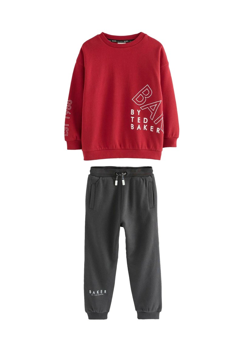 Red long-sleeve sweatshirt with white text and dark gray drawstring jogger pants featuring side pockets and cuffed ankles.