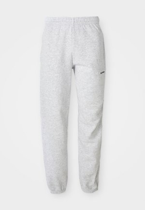 Pelēki sporta bikses, kas izgatavotas no mīkstas auduma, ar elastīgu jostu un piedurknēm, ar mazu melnu logo sānos.