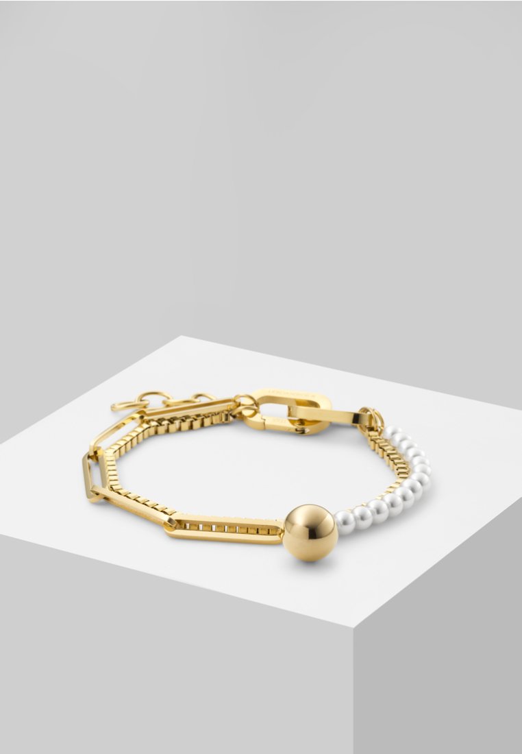 Bracelet en or au design épuré, composé de maillons en or alternés et de perles blanches, surmonté d'un accent rond en or lisse.