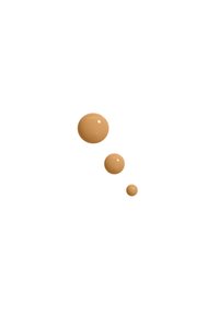 Trois gouttes de liquide brun clair avec une texture lisse et brillante, de tailles variées, se détachant sur un fond blanc.