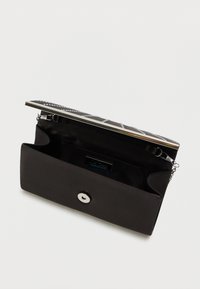 Must musta kott hõbedase metallraamiga, millel on tekstureeritud ülemine osa ja nööbikinnitus. Sisemus sisaldab sektsiooni ja logodetaile.