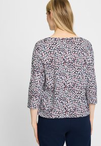 Bluse mit floralem Muster in dunklem Marineblau mit rosa und hellblauen Akzenten. Verfügt über Dreiviertelärmel und ein lässiges Schnittdesign.