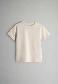 Camiseta de manga corta color beige claro, hecha de algodón suave. Cuello redondo clásico con corte recto, sin patrones ni acentos visibles.