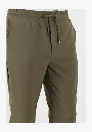 Pantaloni jogger verde oliva realizzati in tessuto testurizzato, dotati di vita elastica con cordino e tasche laterali.