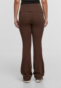 Barna, lágy anyagú, bő szabású nadrág. Magas derék, sima textúrájú és minimalista dizájnnal rendelkezik, alkalmas hétköznapi viseletre.