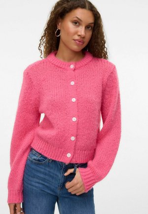 Rosa strikket cardigan med rund hals, lange ærmer og hvide knapper forneden. Teksturen er blød og fuzzy.